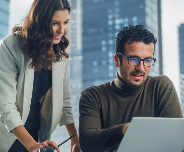 Dos personas analizando datos con calma frente a una laptop